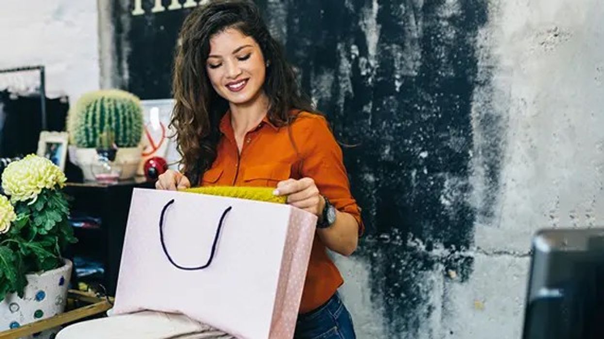 image of retail worker packing goods in a shopping bag