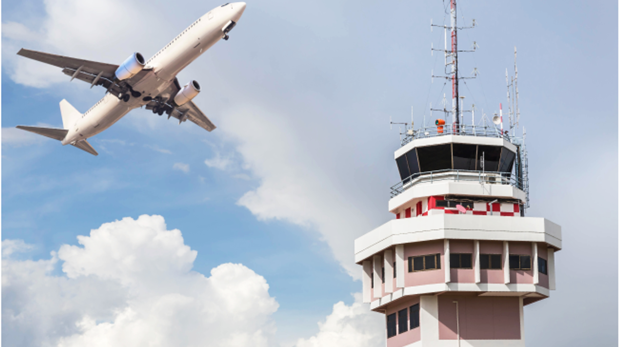 airplane flying past control tower
