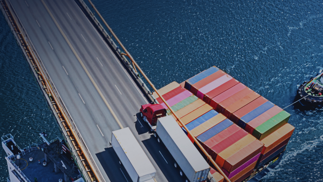 containers on ship passing under bridge